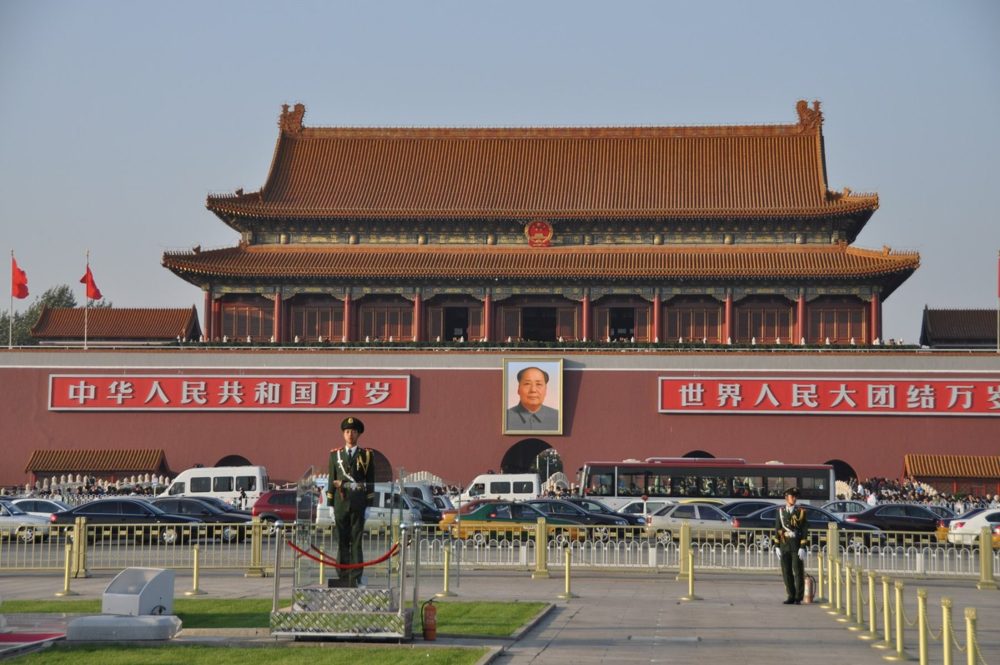 The Gate of Heavenly Peace (Tiananmen) in Beijing, with its central portrait, red banners and honor guards standing out front.