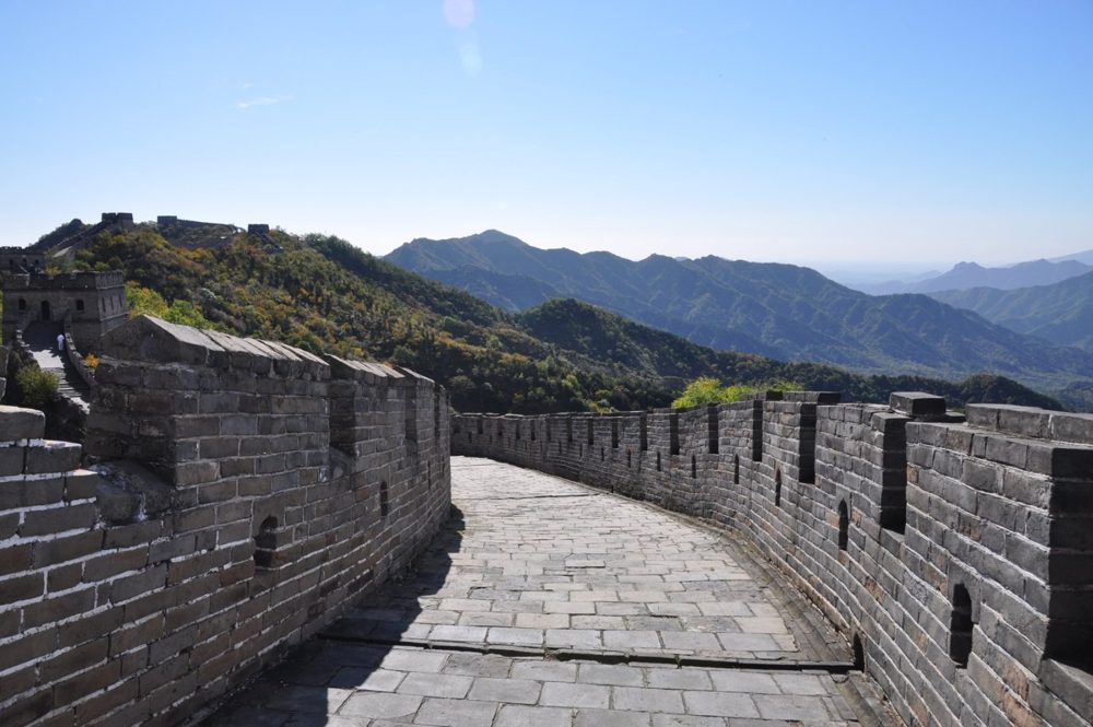 The Great Wall winding along a mountain ridge near Beijing under a clear blue sky.