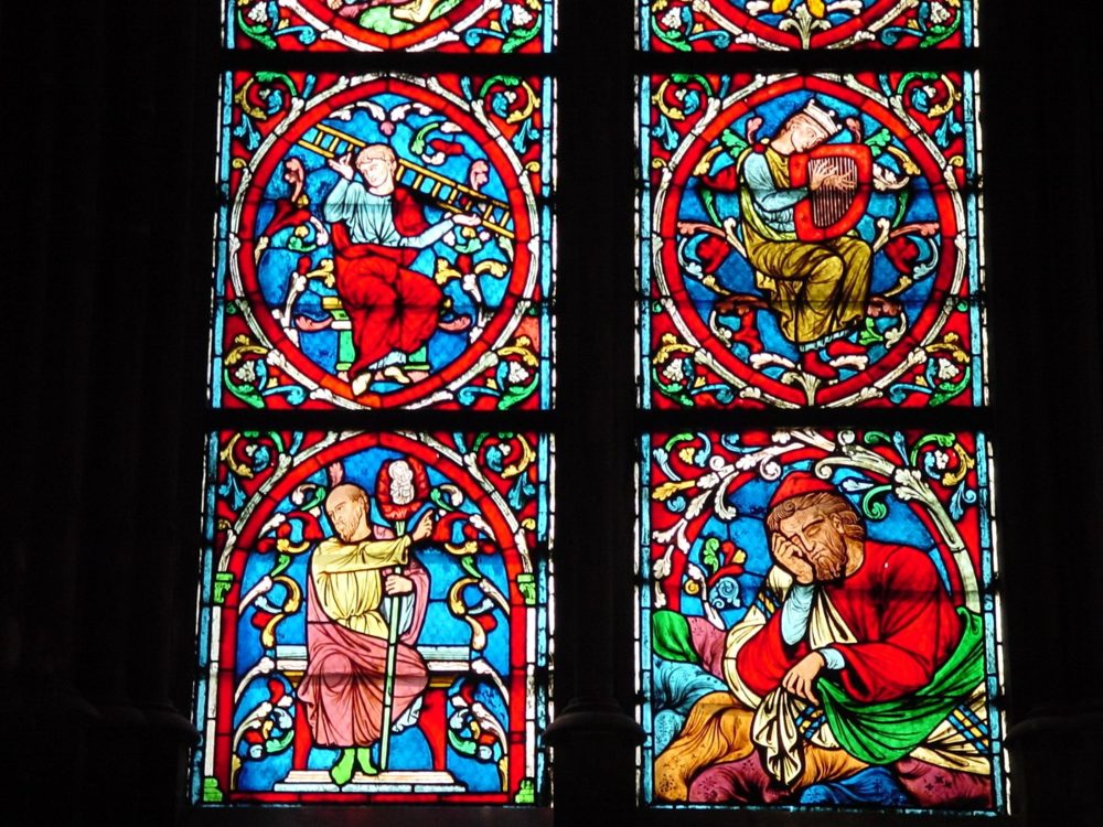 Stained-glass panels in a side window of Notre-Dame, with figures in red, blue and gold.